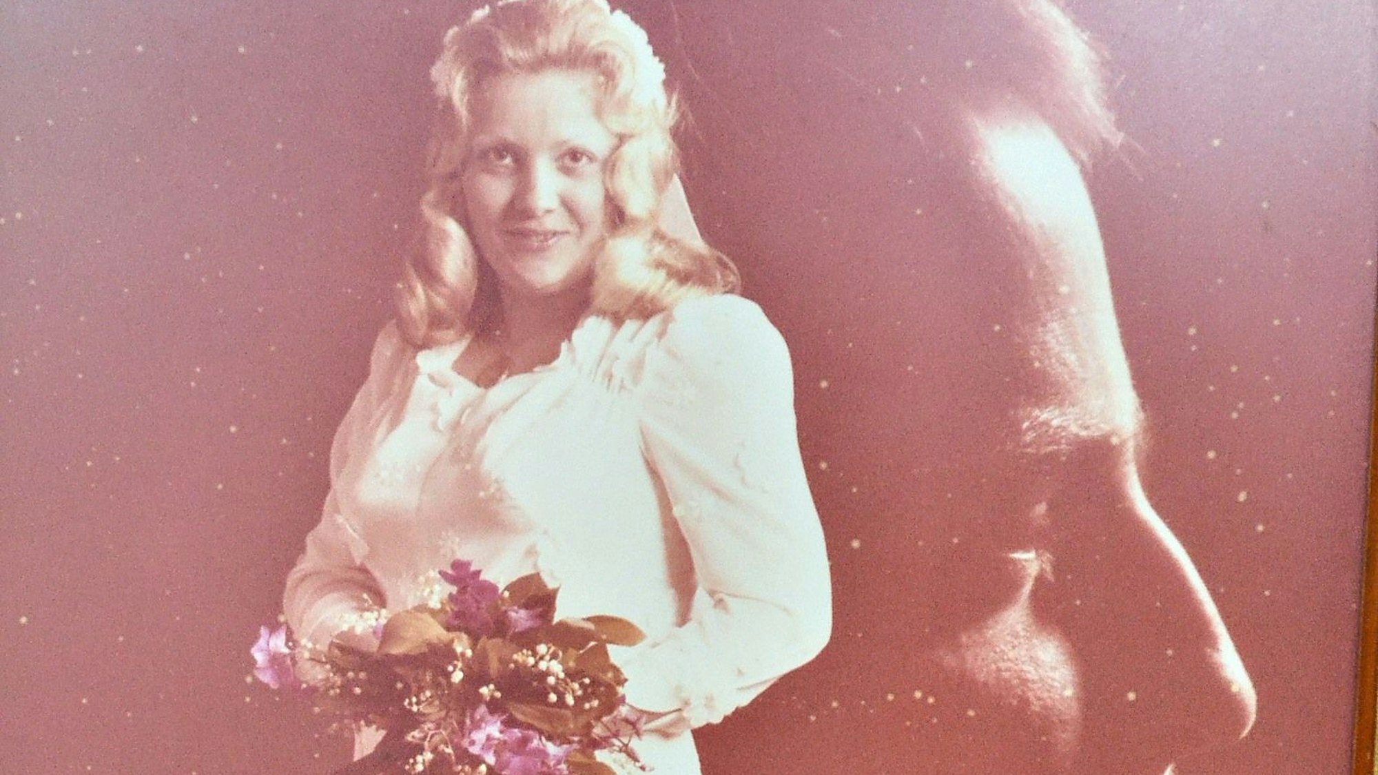 Angelika Bolz im weißen Hochzeitskleid, dahinter ist der Kopf von Heinz Dieter Bolz kunstvoll in das Bild montiert worden.