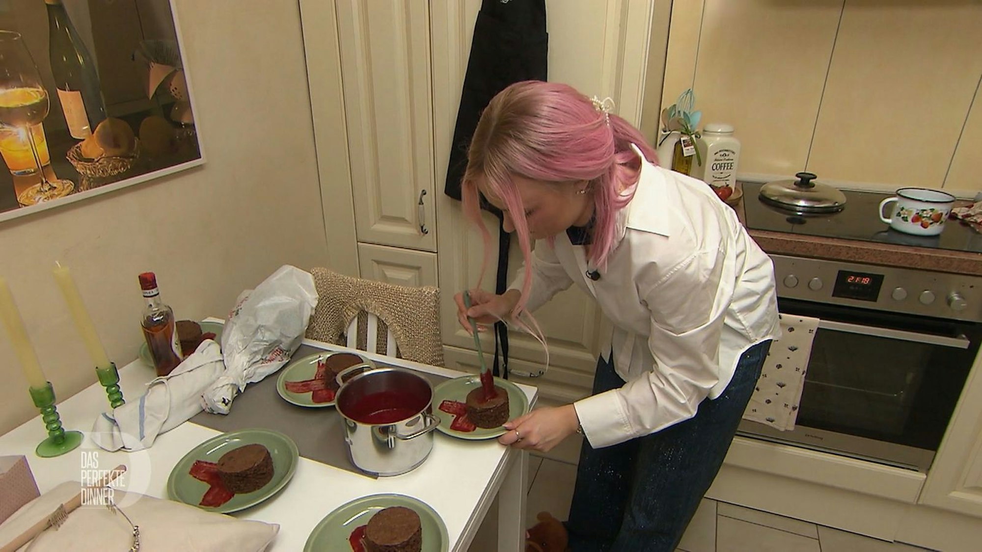 Jil bepinselt die Sacherschnitten mit Himbeersoße und Schokoglasur.
(Bild: RTL)