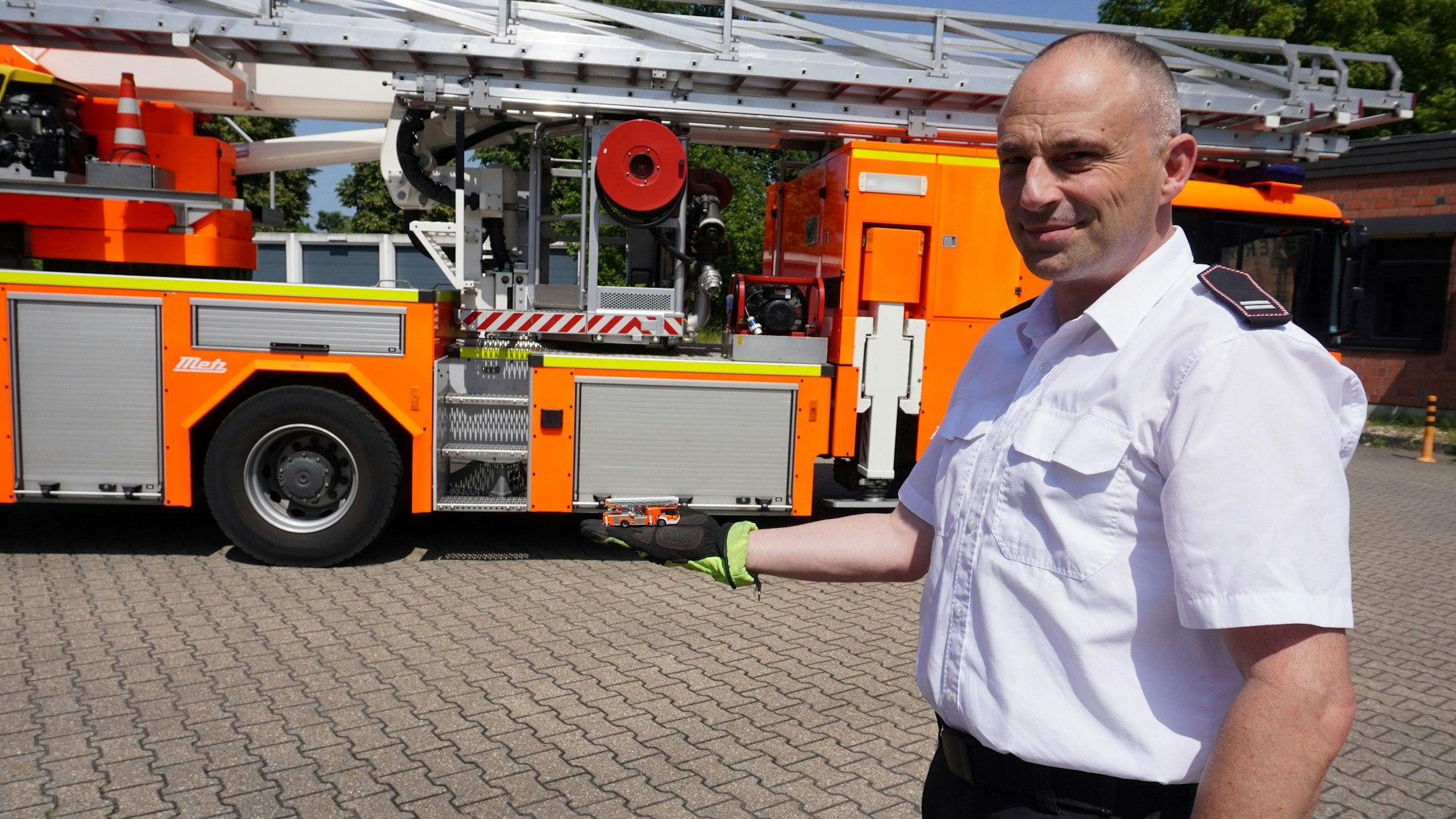 Das Foto zeigt einen Mann vor einem Feuerwehrfahrzeug.