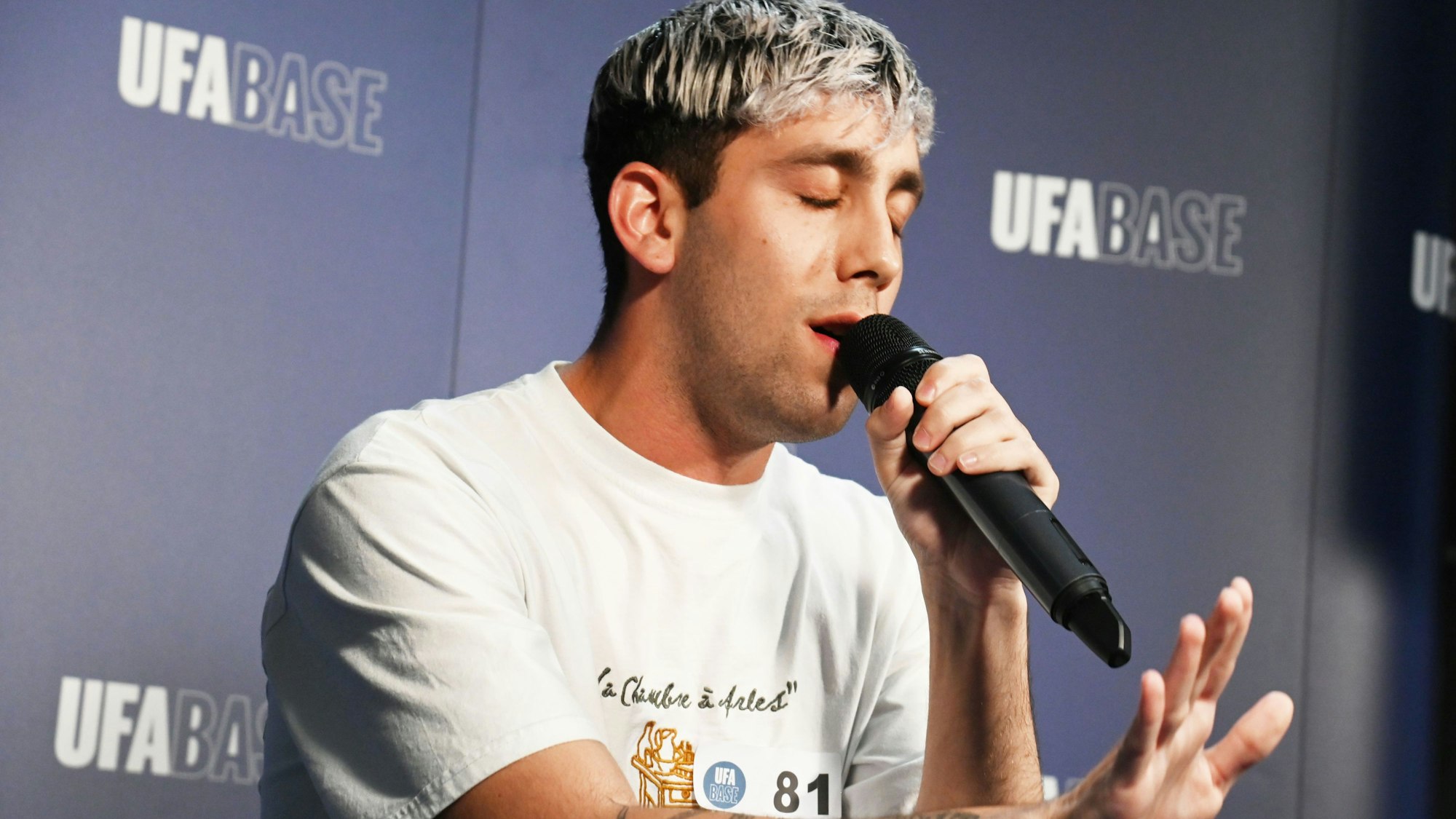 Ein Mann hält ein Mikrofon in der Hand und singt.