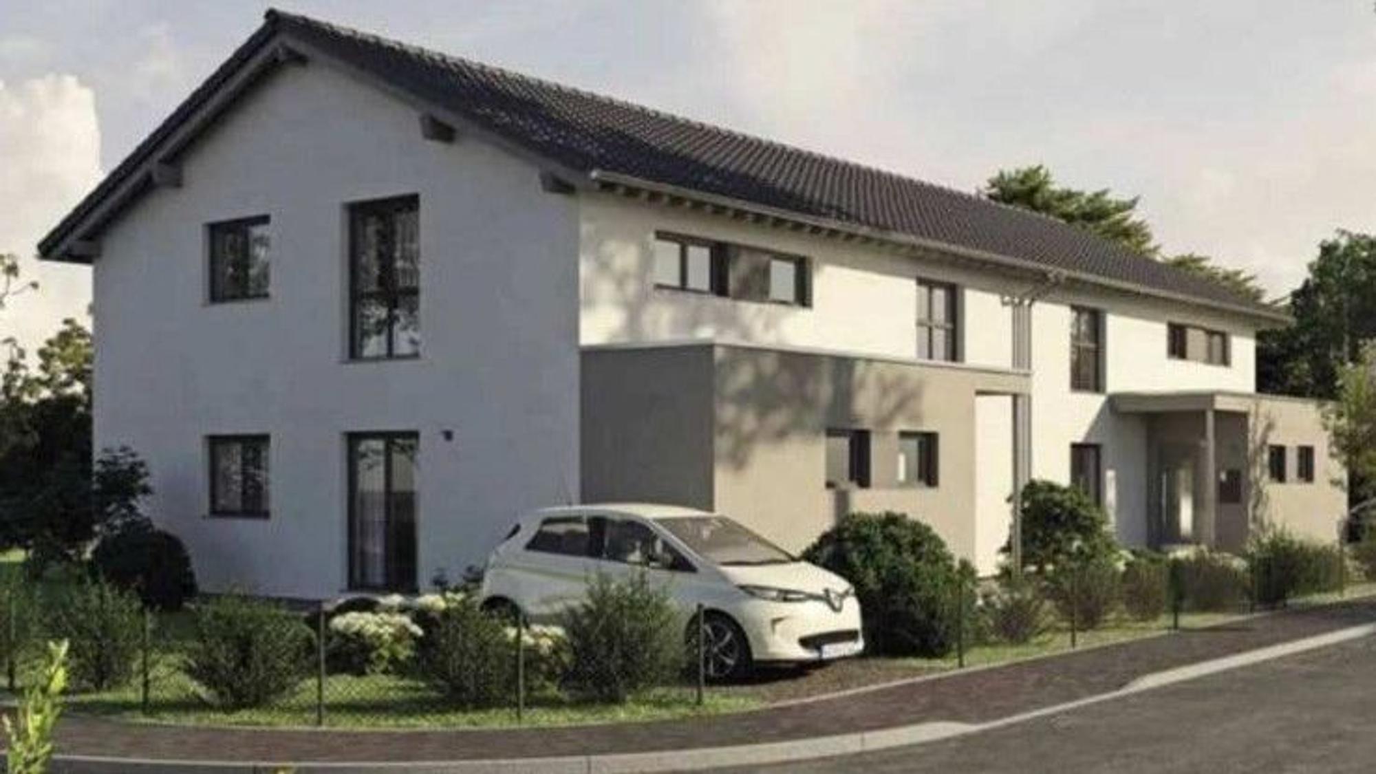 Vor einem Mehrfamilienhaus, das wie ein Einfamilienhaus aussieht, steht ein Auto.