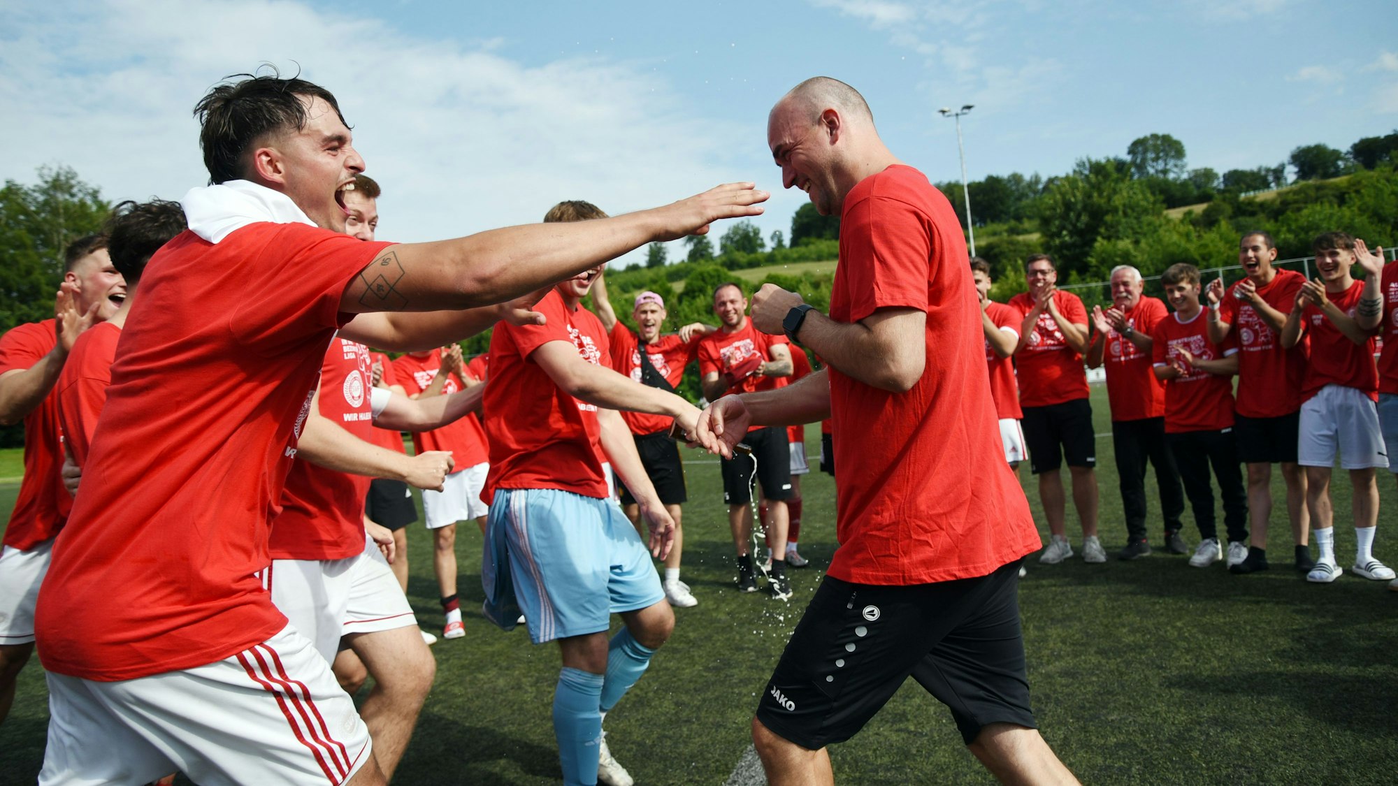 Fußballer fordern ihren Trainer zur Bierdusche.