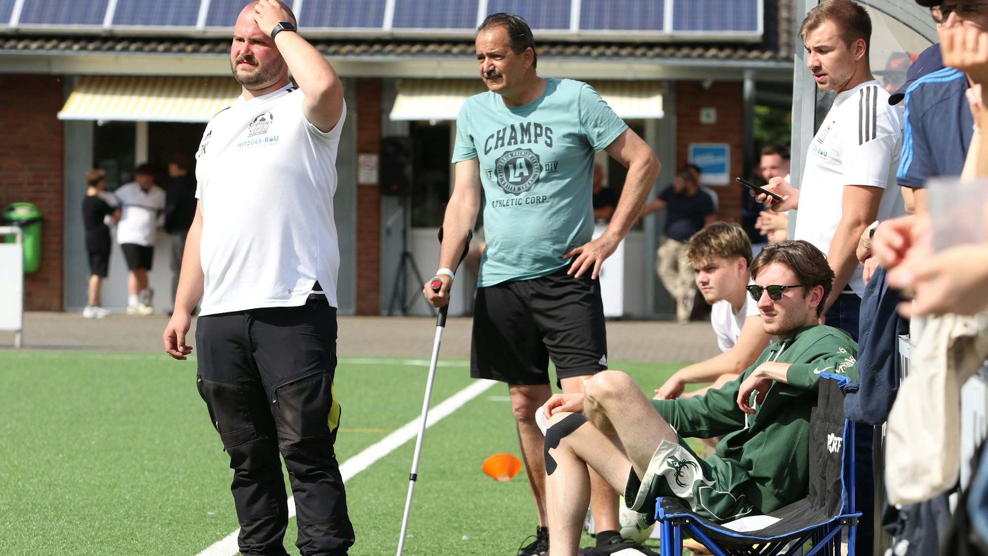 Das Bild zeigt den Coach, der mit einer Krücke am Spielfeldrand steht.