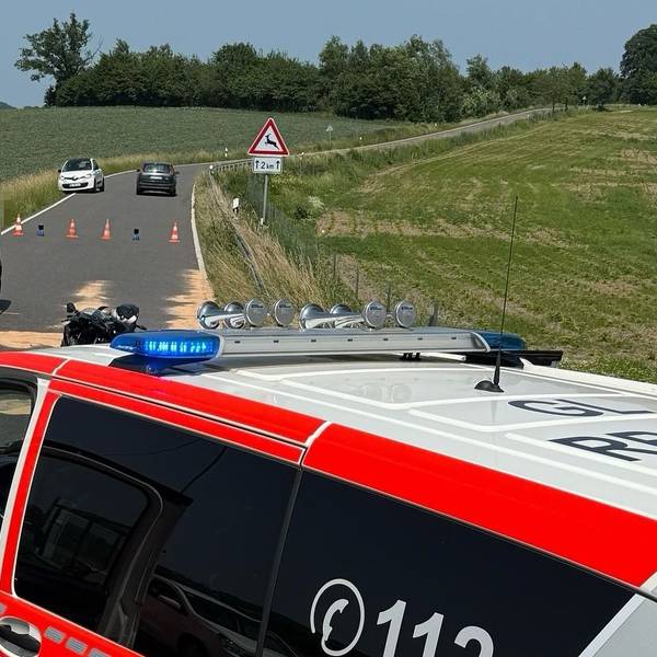 Ein Unfallauto steht auf der Landstraße 84 bei Overath. Im Vordergrund ist ein Notarzteinsatzfahrzeug zu sehen.
