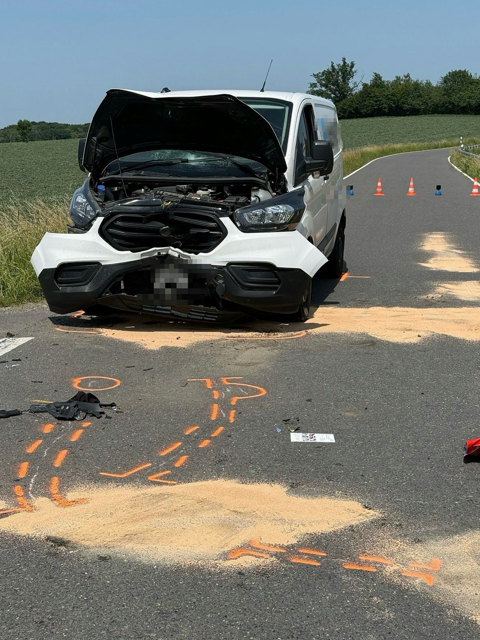 Ein Unfallauto steht auf der Landstraße bei Overath-Leffelsend, auf dem Boden sind Unfallspuren und -markierungen zu sehen.