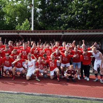 Gruppenfoto einer jubelnden Fußballmannschaft.