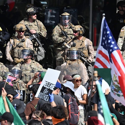 US Marines, California National Guard and Los Angeles Police stand guard on the steps of the Federal Building on June 14, 2025 in Los Angeles, as protesters participating in the "No Kings" demonstration arrived in the area. Tens of thousands of protesters rallied nationwide Saturday against Donald Trump ahead of a huge military parade on the US president's 79th birthday -- as the killing of a Democratic lawmaker underscored the deep divisions in American politics. "No Kings" demonstrators took to the streets in New York, Los Angeles, Chicago, Philadelphia, Houston, Atlanta and hundreds of other cities across the United States to condemn what they call Trump's dictatorial overreach. (Photo by Robyn Beck / AFP)