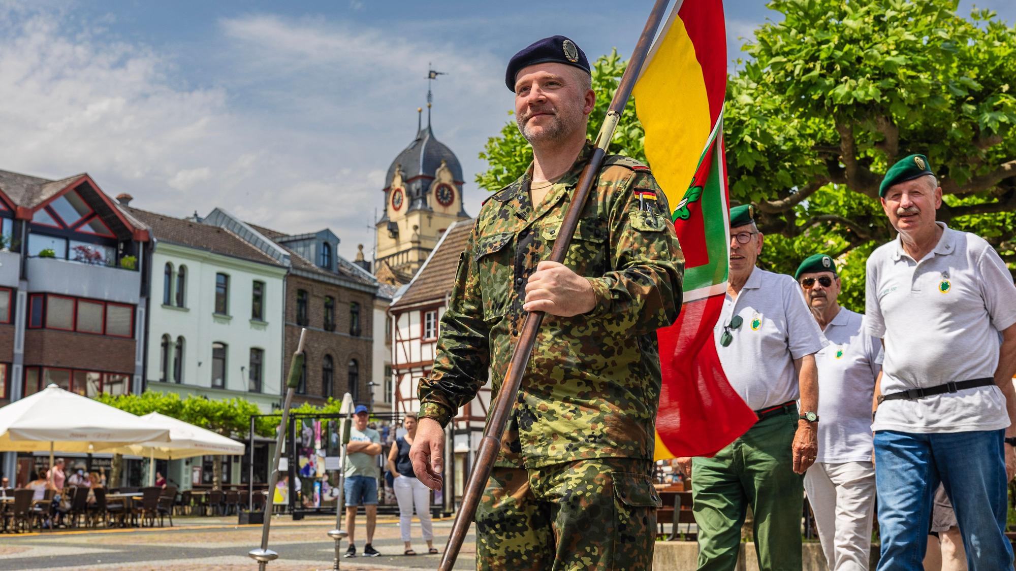 Mit einer Fahne voran zieht die Kameradschaft ehemaliger Euskirchener Jäger über den Alten Markt mit dem alten Rathaus im Hintergrund.