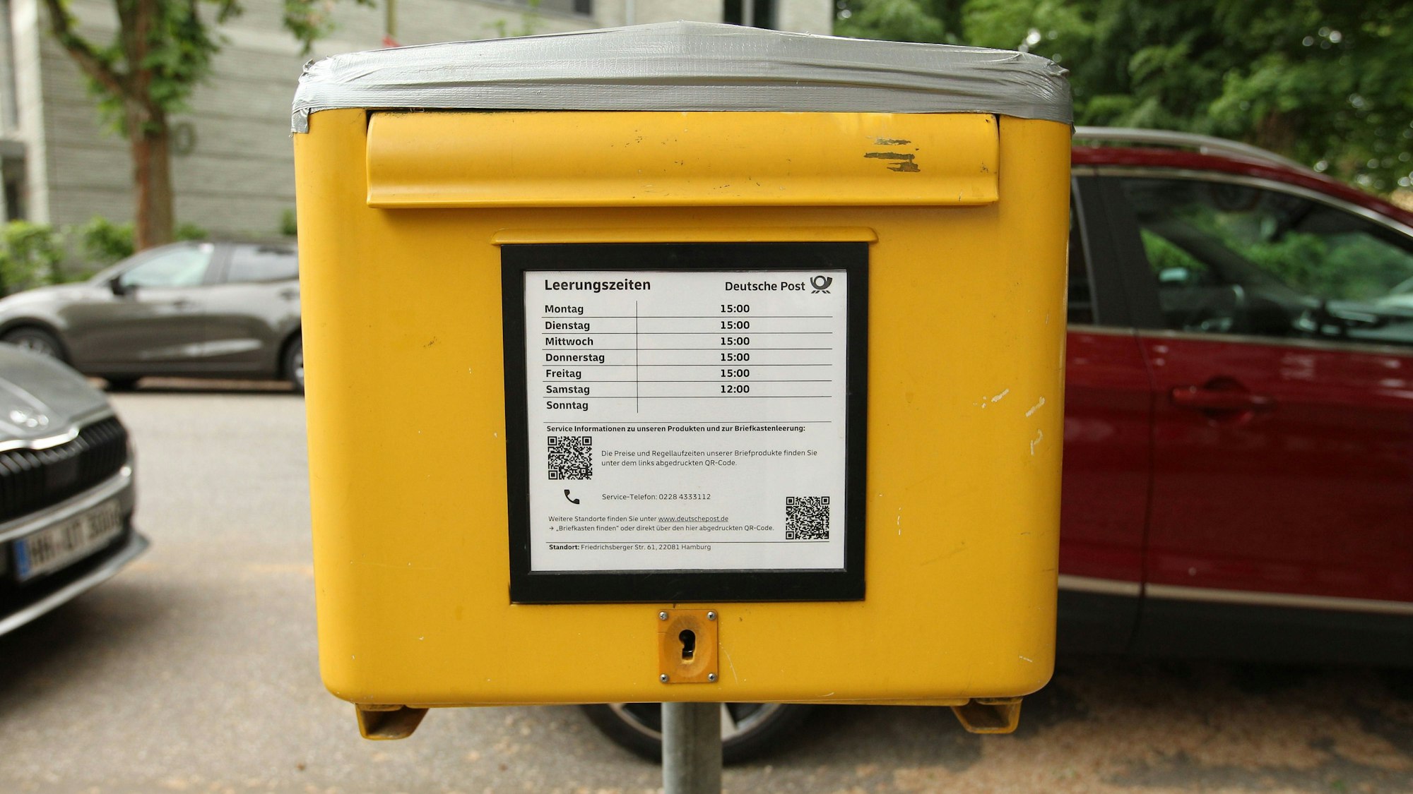 Ein Postbriefkasten der Deutschen Post AG steht mit QR-Codes am Anfang einer Seitenstraße. (Archivbild)