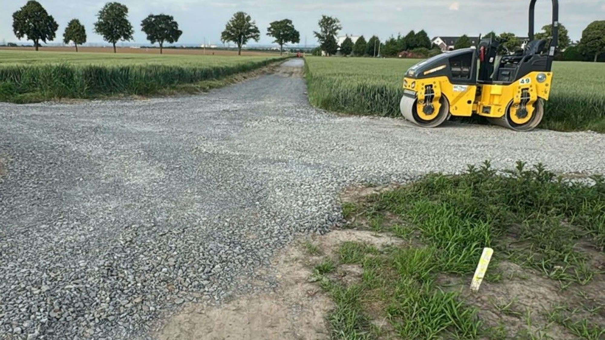 Auf dem Bild sind Feldwege, Felder und eine Baumaschine zu sehen.