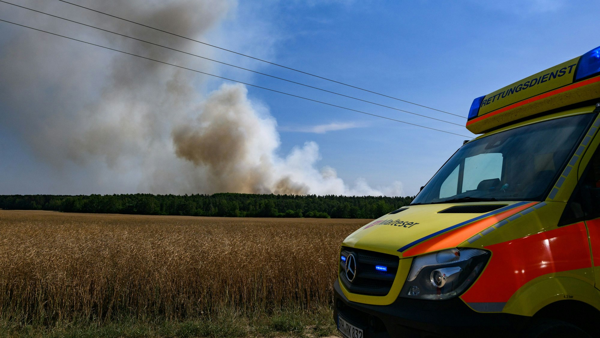 Ein Einsatzwagen fährt an einer Rauchwolke vorbei (Symbolfoto).