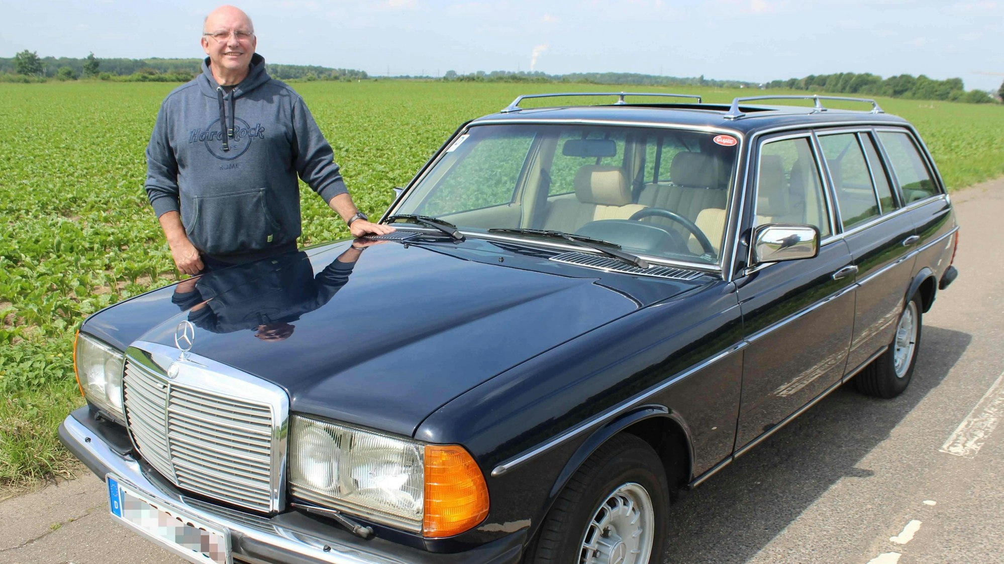 Wilfried Giesen steht neben seinem Mercedes auf einer Landstraße.