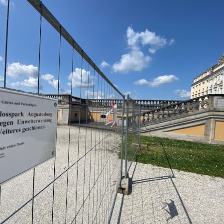 Zu sehen ist ein Zaun, an dem ein Aushang befestigt ist. Dieser weist auf die Sperrung des Parks hin.