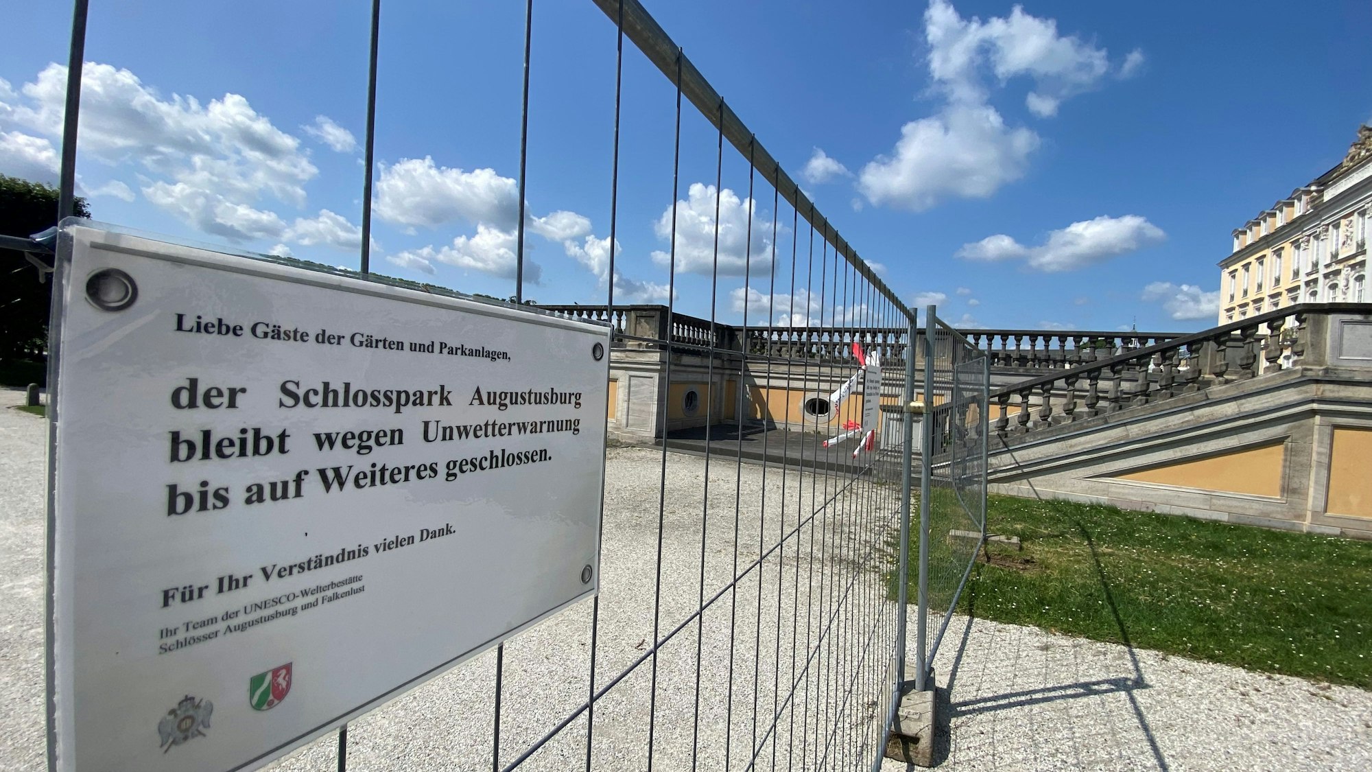 Zu sehen ist ein Zaun, an dem ein Aushang befestigt ist. Dieser weist auf die Sperrung des Parks hin.