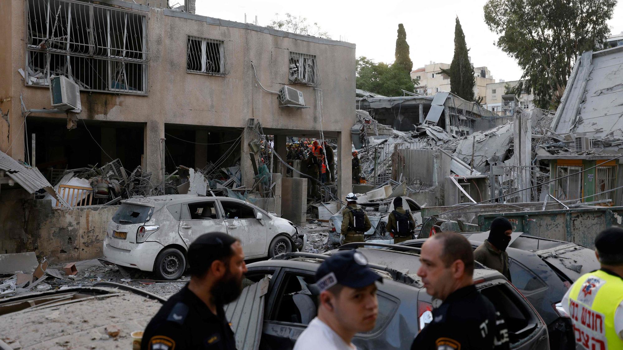 Rescuers work near a damaged building following a strike by an Iranian missile in the Israeli city of Bnei Brak, east of Tel Aviv, on June 16, 2025. Israel's military warned on June 16 of a new missile salvo incoming from Iran, as AFP journalists reported loud explosions in Jerusalem and fires outside the coastal city of Haifa. "A short while ago, the IDF identified missiles launched from Iran toward the territory of the State of Israel," the army posted on Telegram, using the acronym for its official name. (Photo by Jalaa MAREY / AFP)
