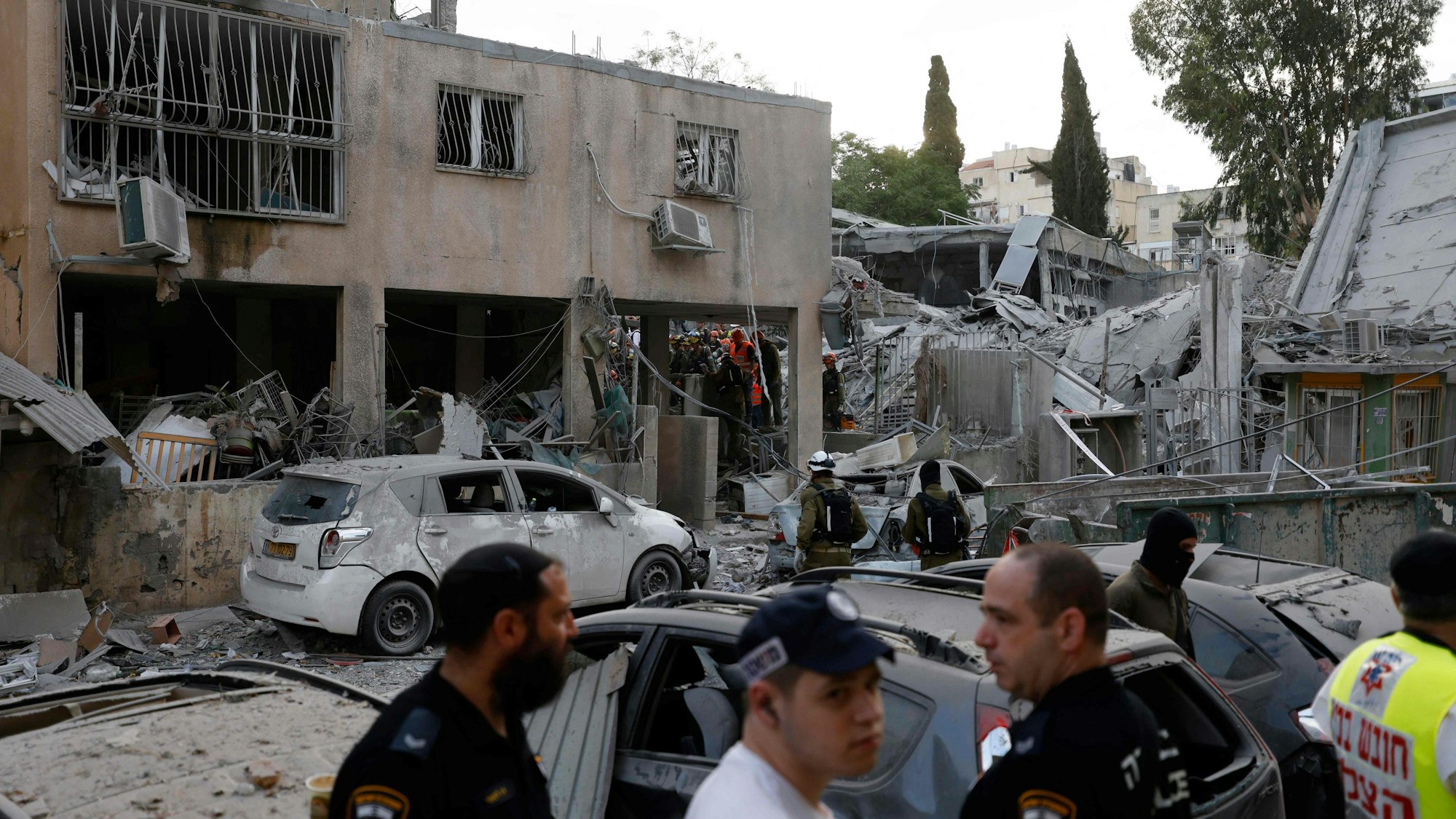 Rescuers work near a damaged building following a strike by an Iranian missile in the Israeli city of Bnei Brak, east of Tel Aviv, on June 16, 2025. Israel's military warned on June 16 of a new missile salvo incoming from Iran, as AFP journalists reported loud explosions in Jerusalem and fires outside the coastal city of Haifa. "A short while ago, the IDF identified missiles launched from Iran toward the territory of the State of Israel," the army posted on Telegram, using the acronym for its official name. (Photo by Jalaa MAREY / AFP)
