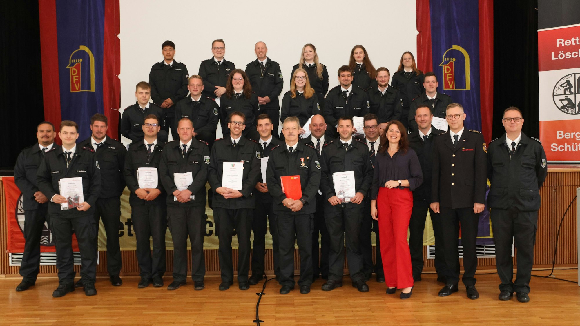 Gruppenfoto von Feuerwehrleuten und einer Bürgermeisterin.