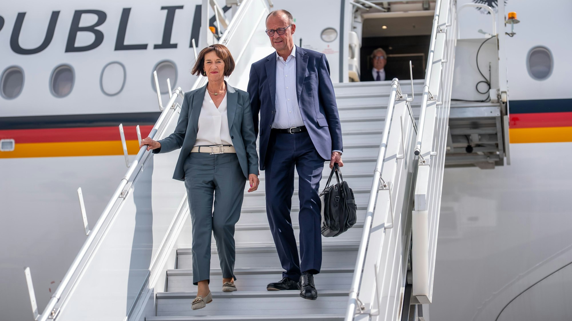 15.06.2025, Kanada, Calgary: Bundeskanzler Friedrich Merz (CDU) kommt in Begleitung seiner Frau Charlotte Merz zum G7-Gipfel der Staats- und Regierungschefs auf dem Flughafen in Calgary an. Das Gipfeltreffen findet in der Pomeroy Kananaskis Mountain Lodge statt. Foto: Michael Kappeler/dpa +++ dpa-Bildfunk +++