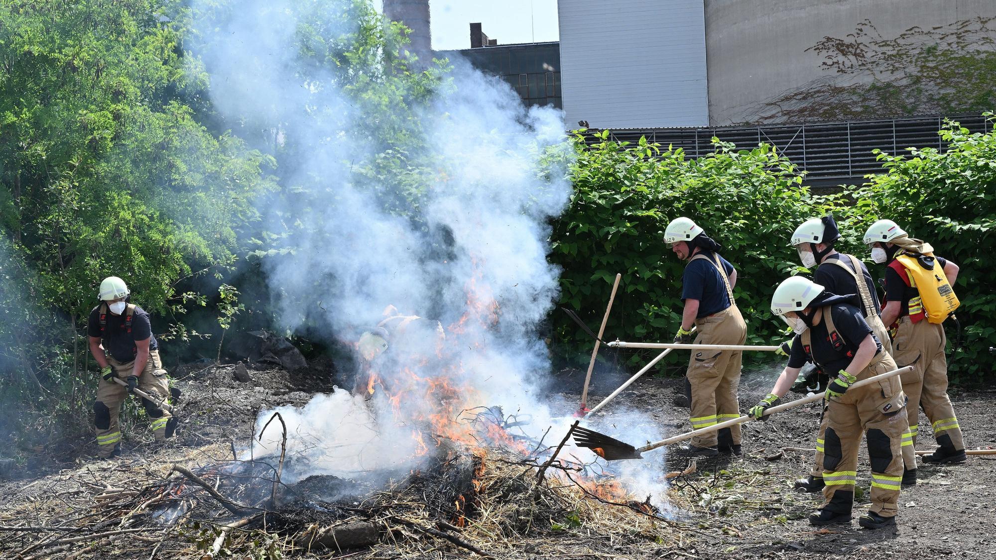 Feuerwehrleute bekämpfen einen Flächenbrand bei der Jahresübung der Feuerwehr Bergisch Gladbach.