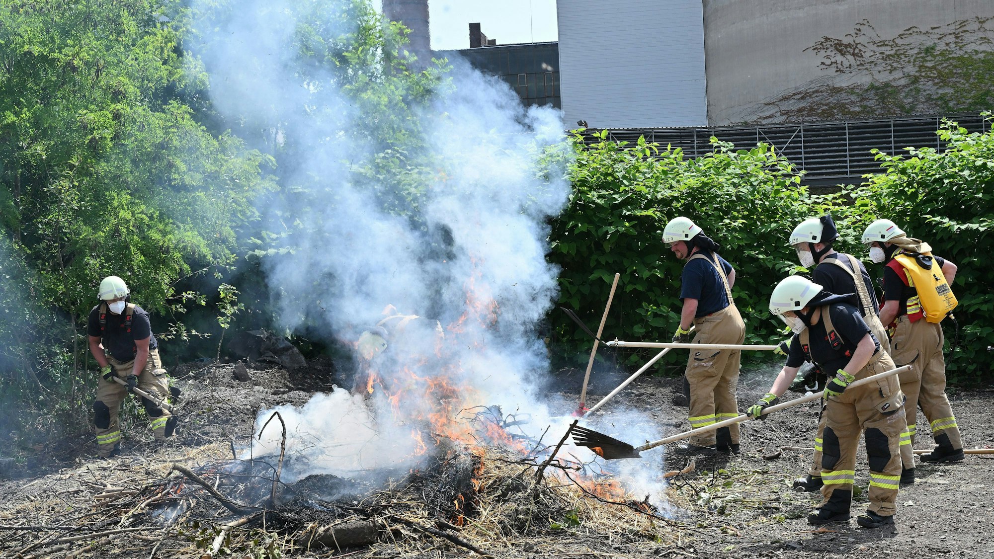 Feuerwehrleute bekämpfen einen Flächenbrand bei der Jahresübung der Feuerwehr Bergisch Gladbach.
