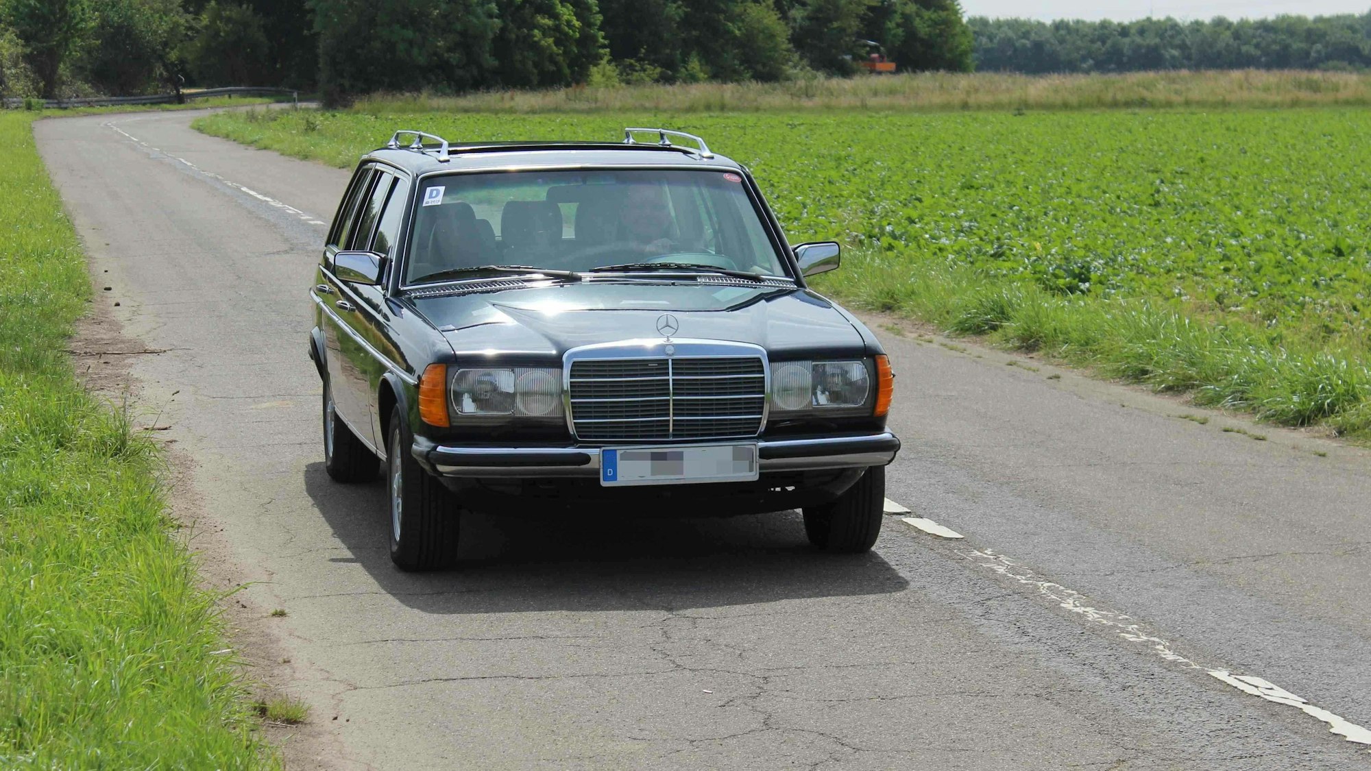 Der Mercedes fährt über eine Landstraße.
