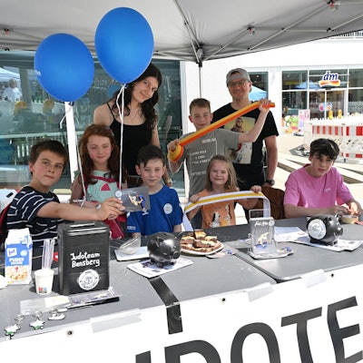 Kinder und Erwachsene stehen hinter einem Stand beim Bensberger Schlosstadtfest.