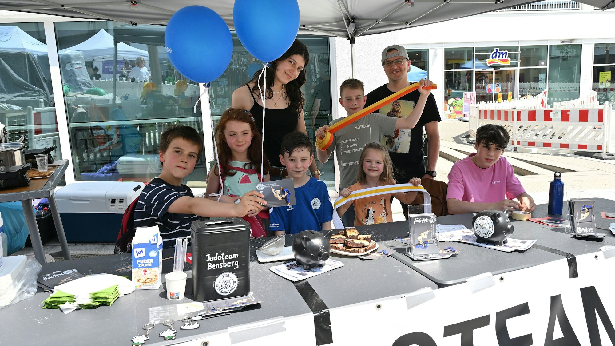 Kinder und Erwachsene stehen hinter einem Stand beim Bensberger Schlosstadtfest.