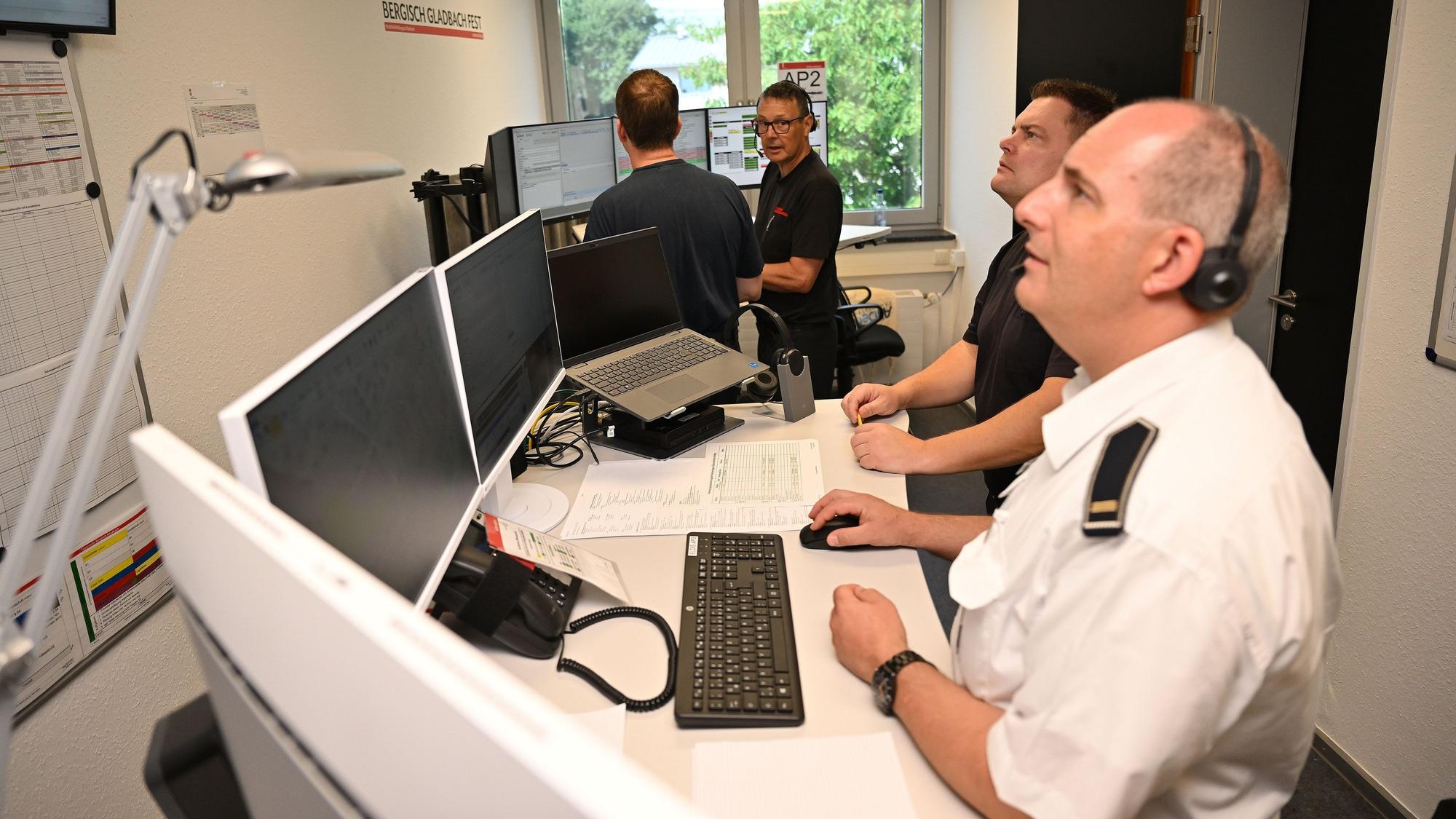 Feuerwehrleute disponieren bei der Jahresübung der Feuerwehr Bergisch Gladbach per Funk die Einsätze.