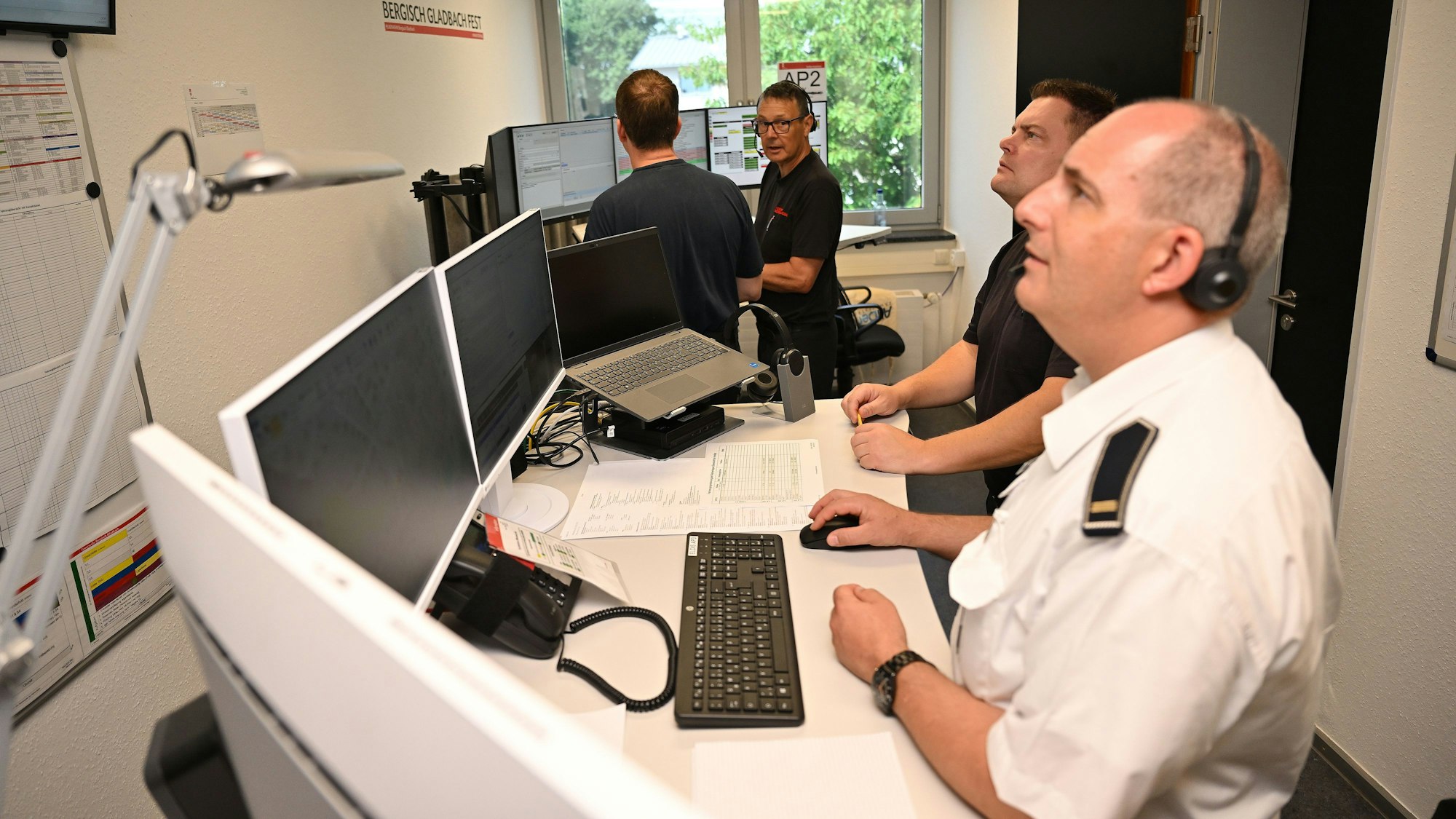 Feuerwehrleute disponieren bei der Jahresübung der Feuerwehr Bergisch Gladbach per Funk die Einsätze.