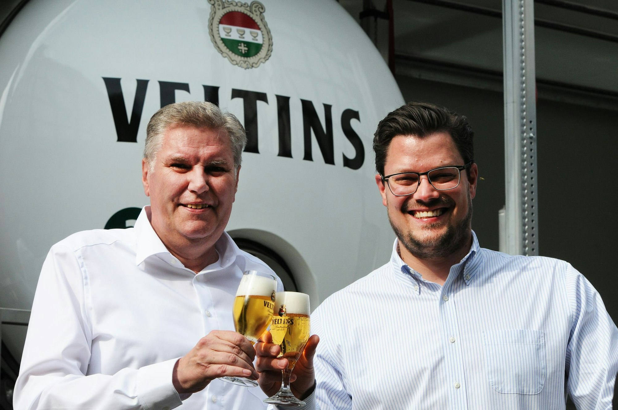 Der Sprecher der Geschäftsführung von Veltins, Volker Kuhl (links), steht im Sommer 2024 bei einer Firmenveranstaltung neben Fabian Veltins.