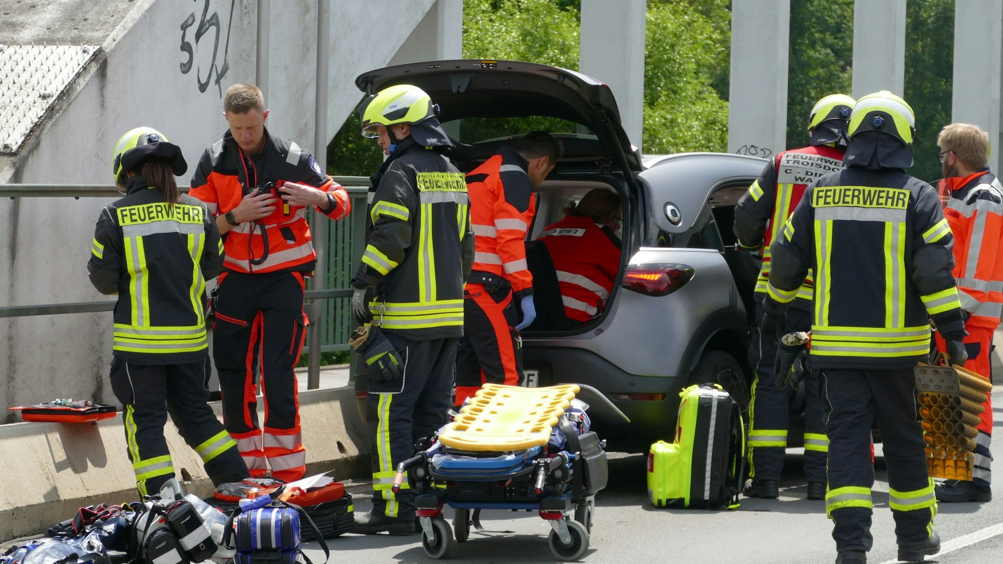 Einsatzkräfte von Feuerwehr und Rettungsdienst an einem Unfallort.