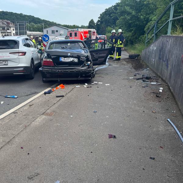 Zwei Unfallautos stehen in Kürten-Broich nebeneinander. Im Hintergrund sind Feuerwehrleute und Rettungsdienst zu sehen.