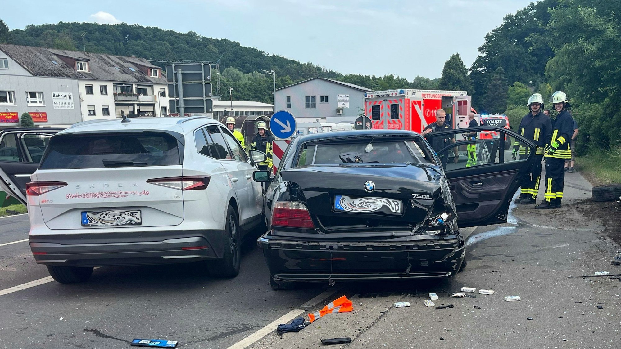 Zwei Unfallautos stehen in Kürten-Broich nebeneinander. Im Hintergrund sind Feuerwehrleute und Rettungsdienst zu sehen.