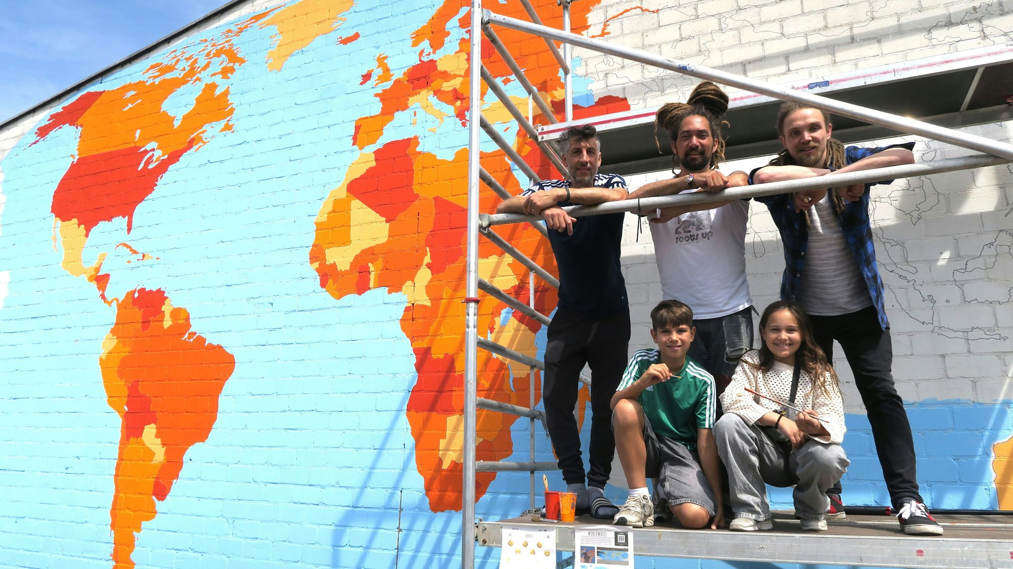 Weltmaler bei der Arbeit: Hendrik Pfäfflin (stehen Mitte) mit seinen Helfern Thibault Chermette und Felix Schmid (stehend v.l.), Yul und Maxine (knieend v. l.) auf dem Gerüst.