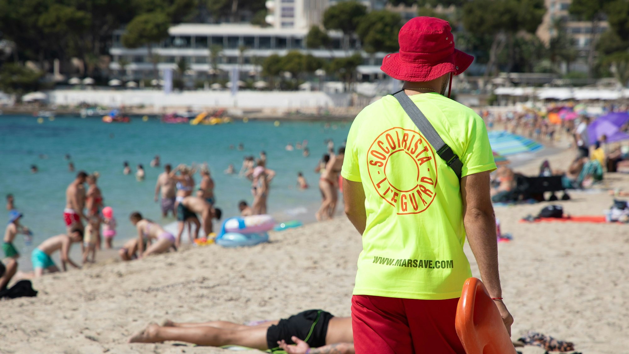 Ein Rettungsschwimmer geht am Strand von Magaluf auf Mallorca entlang.