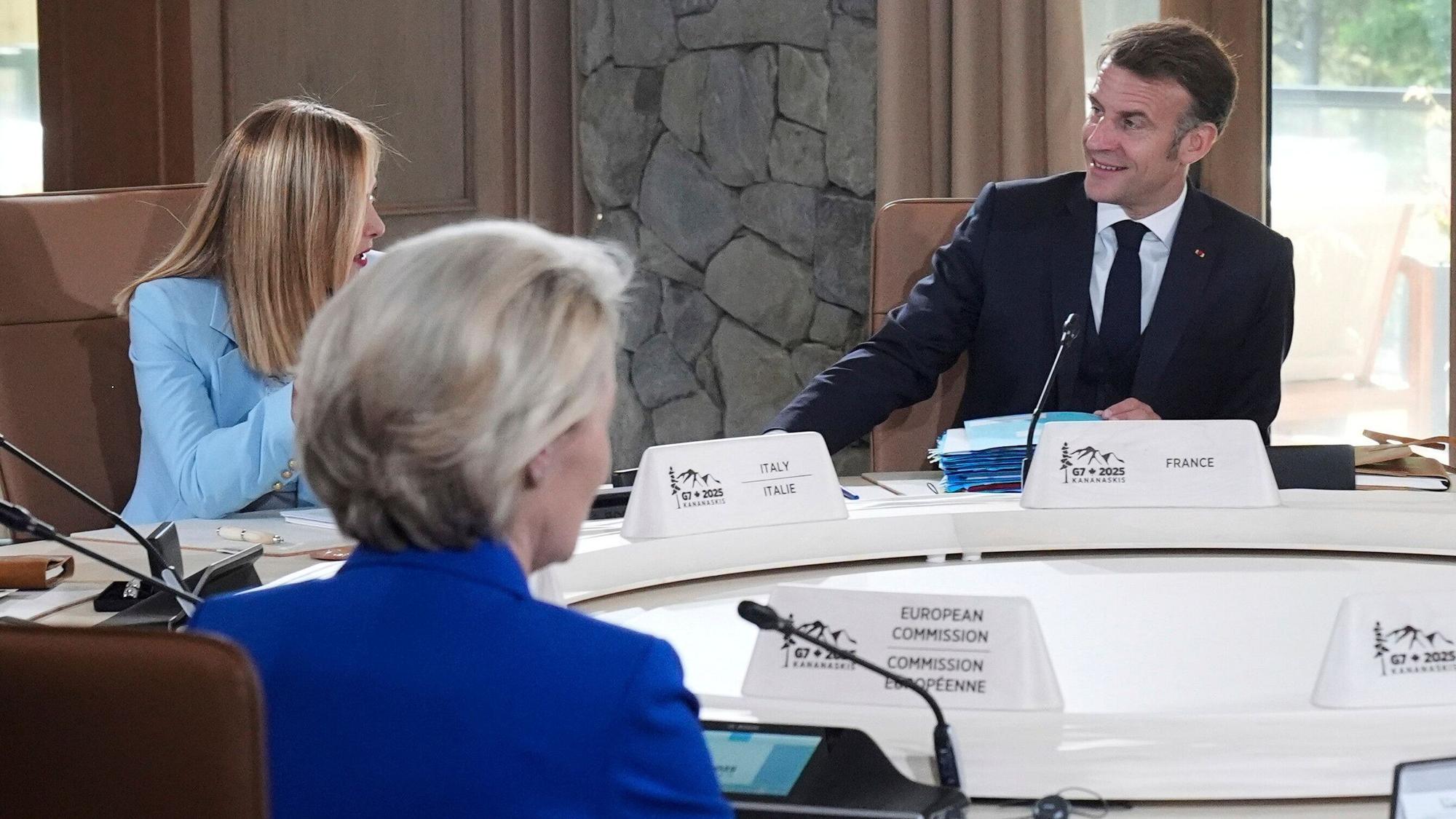 Giorgia Meloni (l), Ministerpräsidentin von Italien, spricht mit Emmanuel Macron, Präsident von Frankreich, bei einer Sitzung des G7-Gipfels. Gegenüber sitzt Ursula von der Leyen (M), Präsidentin der EU-Kommission.