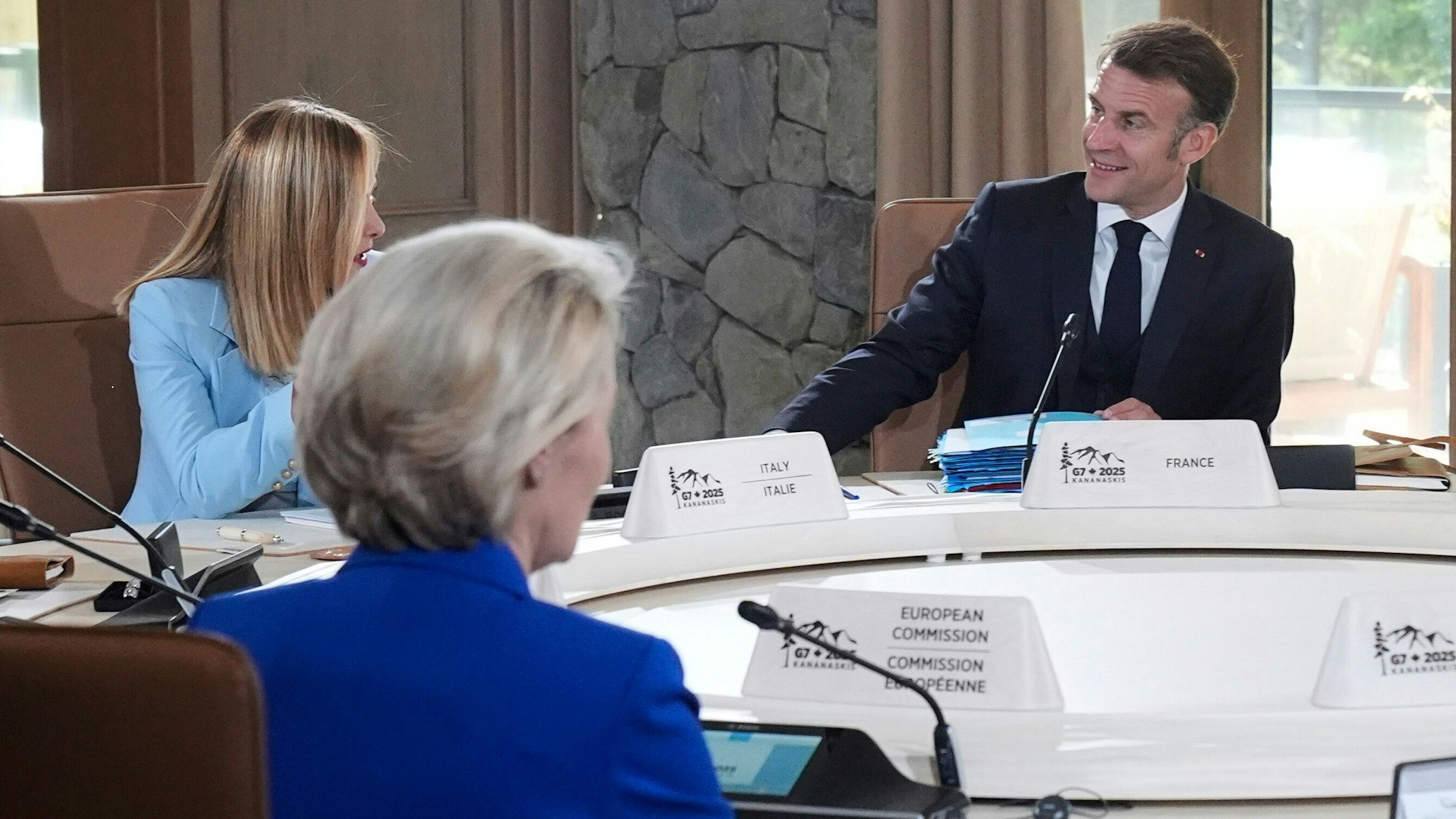 Giorgia Meloni (l), Ministerpräsidentin von Italien, spricht mit Emmanuel Macron, Präsident von Frankreich, bei einer Sitzung des G7-Gipfels. Gegenüber sitzt Ursula von der Leyen (M), Präsidentin der EU-Kommission.