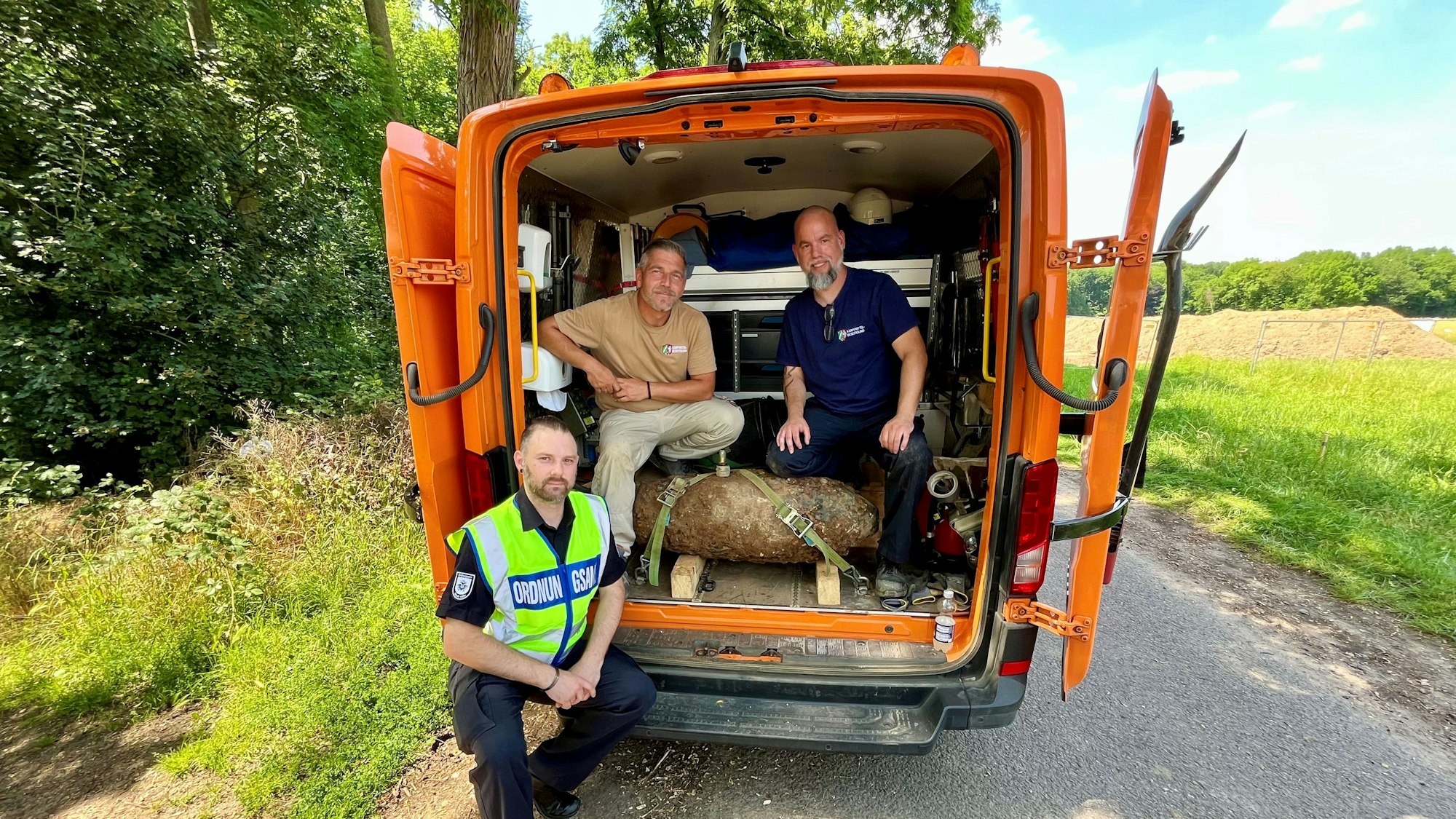 Das Foto zeigt von links nach rechts: Sebastian Baals (Einsatzleitung Ordnungsamt), Marcel Biewald (KBD) und Christoph Wassenberg (KBD) mit der entschärften Bombe in Köln-Rodenkirchen. Foto: Stadt Köln
