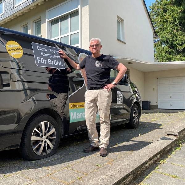 Zu sehen ist Marc Prokop vor dem Kleinbus, dessen Reifen platt sind.