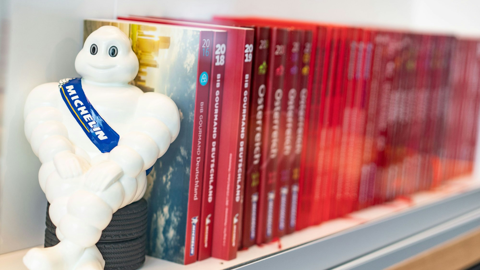 Ein Michelin-Männchen und Guide Michelins verschiedener Jahrgänge stehen im Eingangsbereich am Firmensitz in der Nähe des Frankfurter Flughafens.