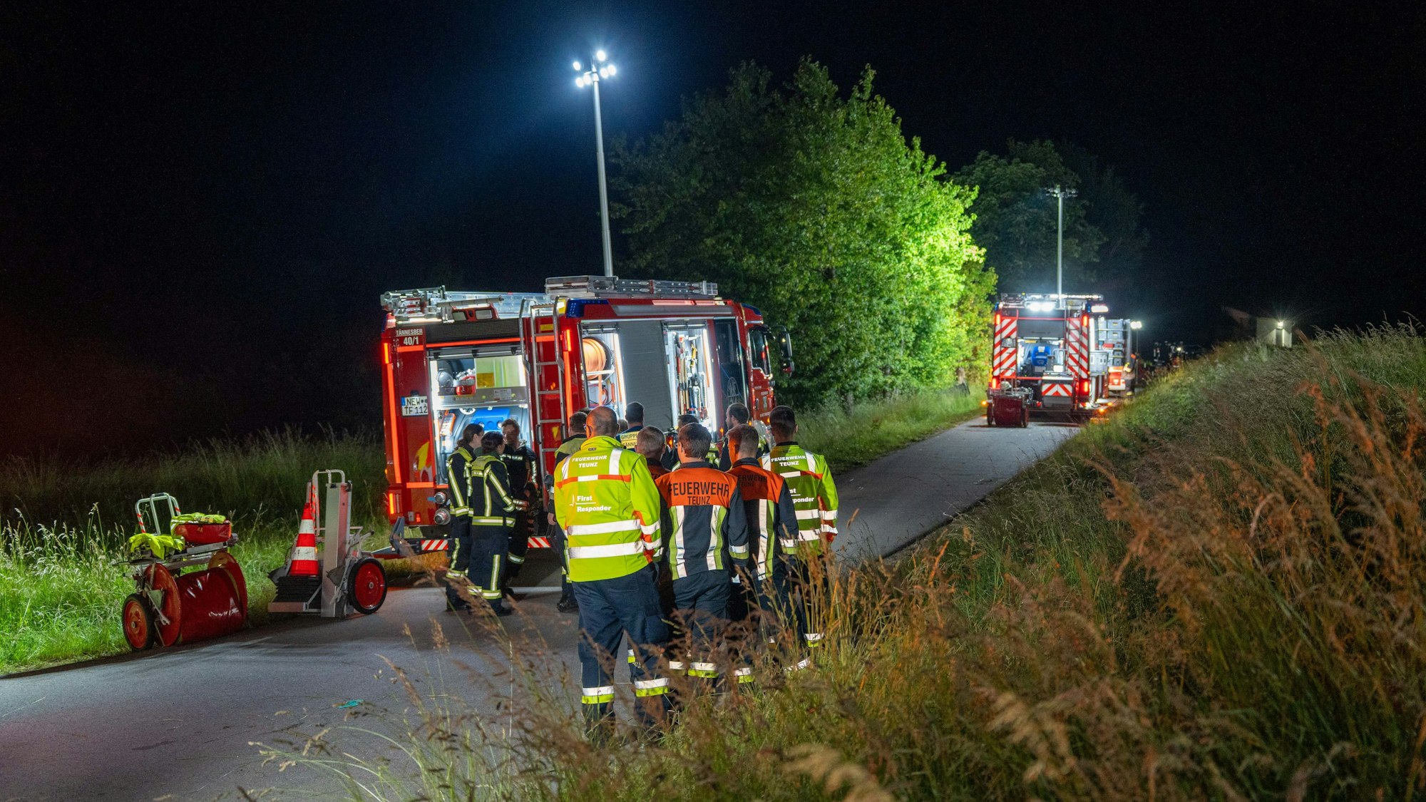 Rettungskräfte stehen vor der Unfallstelle und sind im Einsatz. Bei einem Unfall mit einem Golfkart in Bayern sind zwei Jugendliche gestorben.