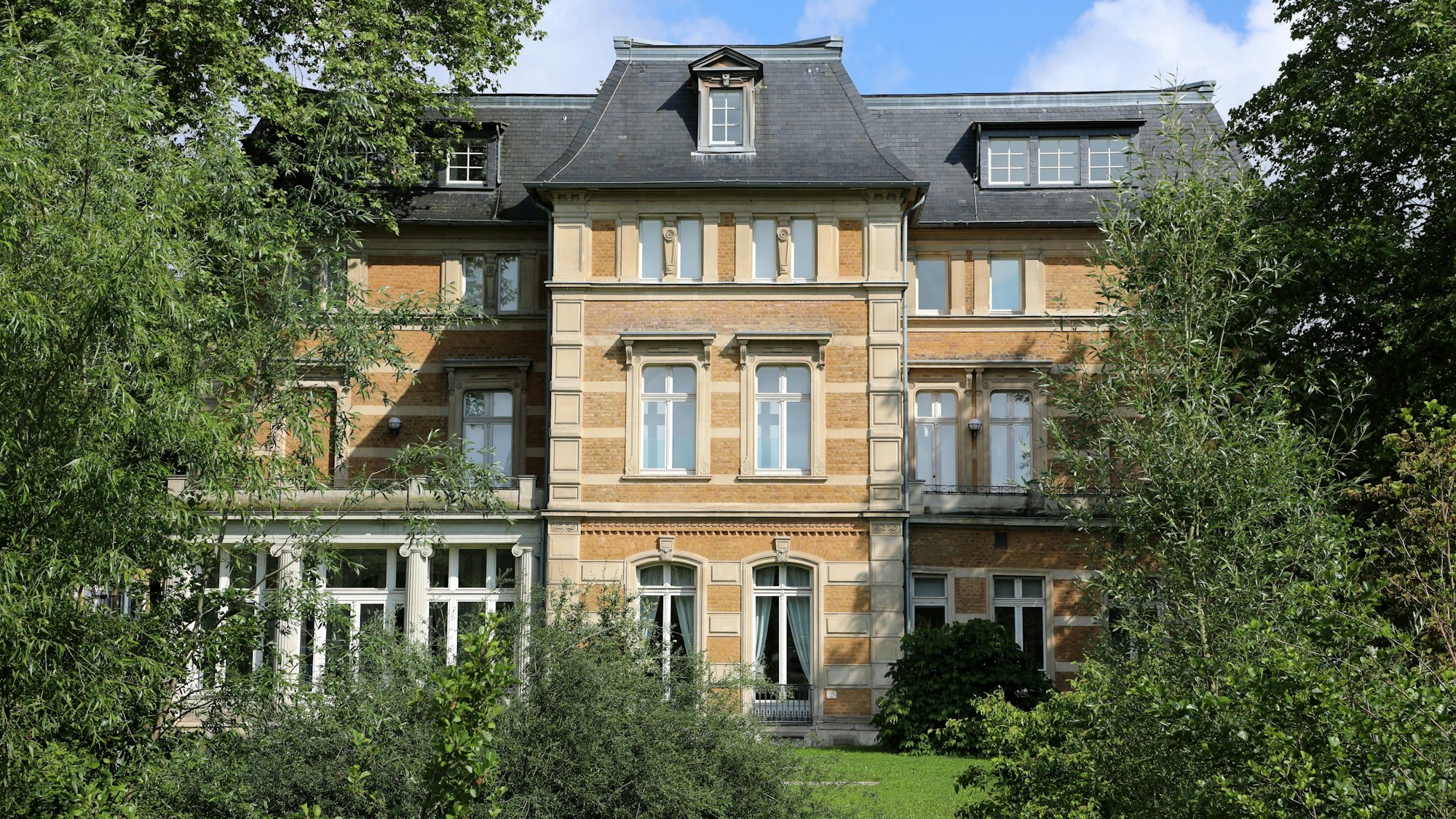 Zwischen Bäumen ist die Villa Zanders in Bergisch Gladbach zu sehen.