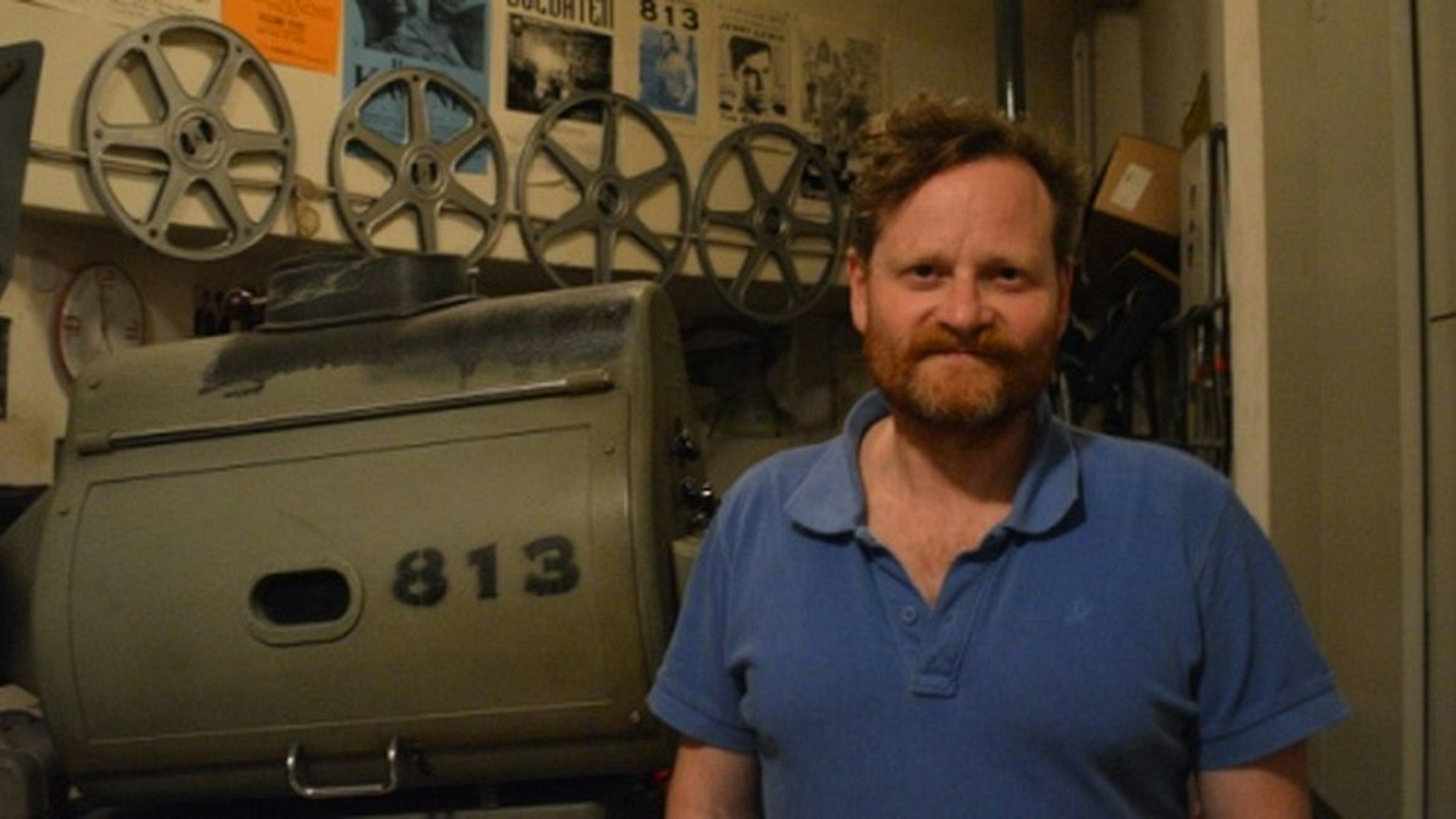 Bernhard Marsch steht vor dem Projektor des Filmclub 813 im Kino in der Hahnenstraße.