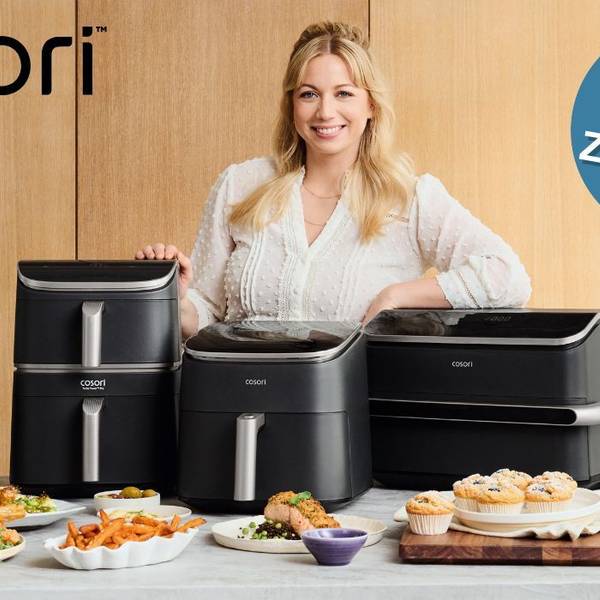 Zora Klipp hinter Tisch mit Cosori Airfryer und Essen.