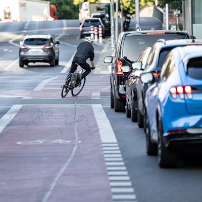 Eine Person fährt mit dem Fahrrad über einen Fahrrad-Schutzstreifen.