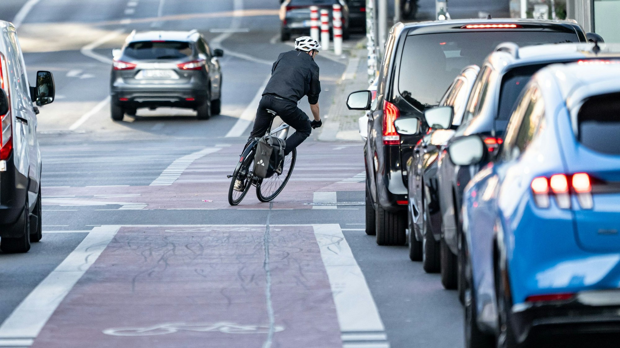 Eine Person fährt mit dem Fahrrad über einen Fahrrad-Schutzstreifen.