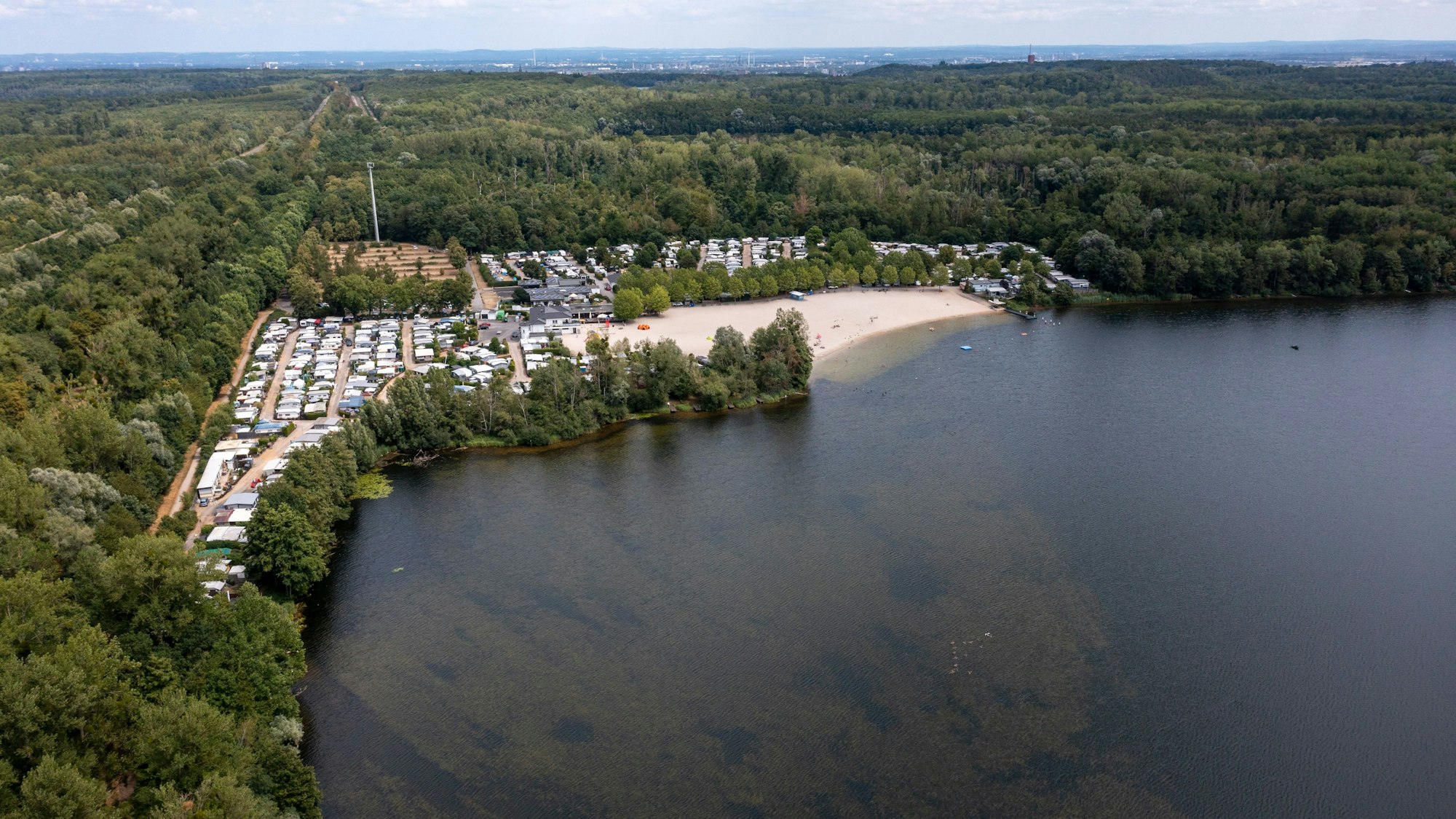 22.07.2023, Erftstadt: Der Liblarer See ist einer der größten Seen der Villeseenplatte. Luftbild mit Drohne zeigt das Ufer mit Campingplatz und Strandbad.