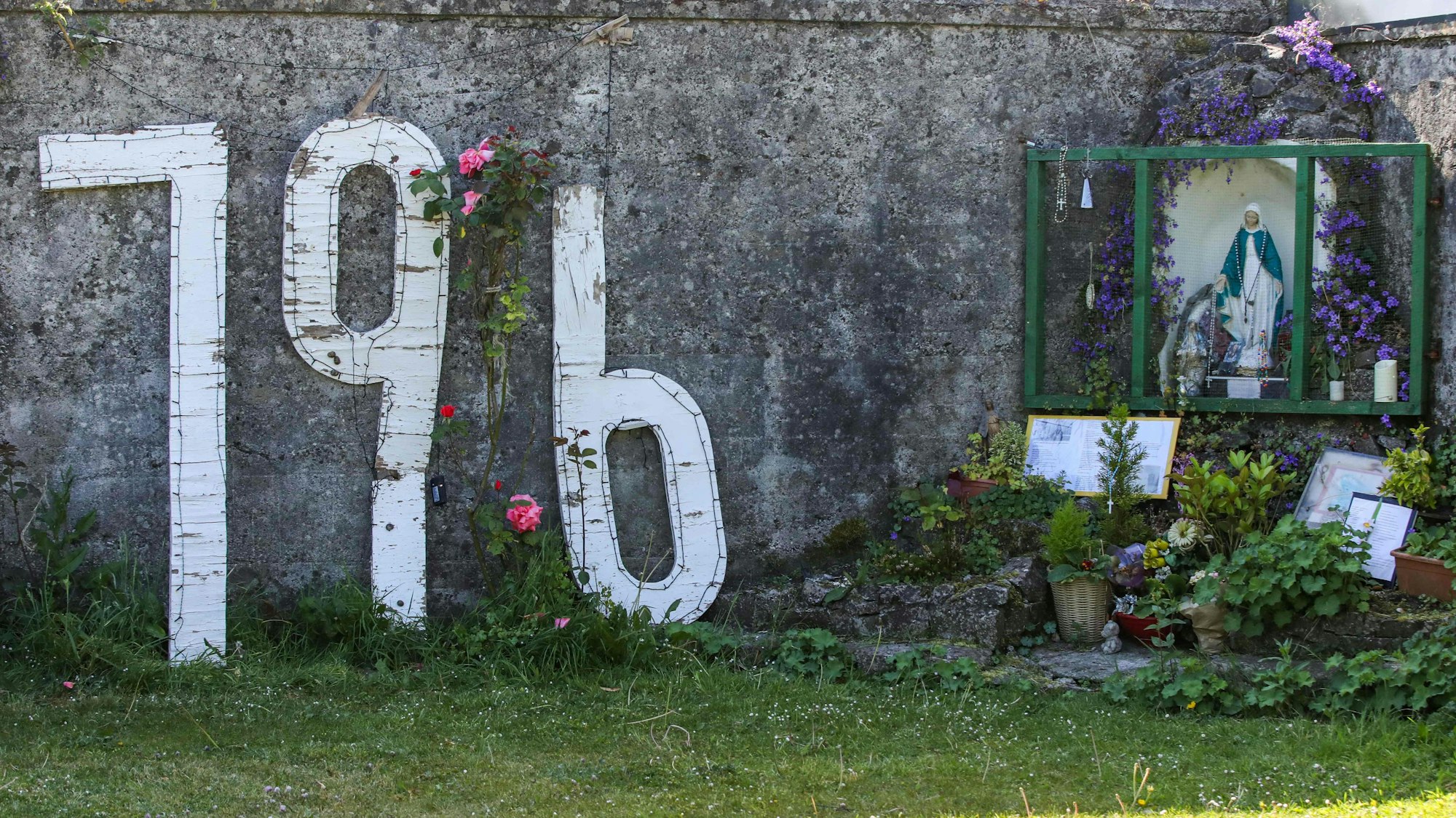 Die Zahl 796 prangt nebst Blumen an einer Mauer.