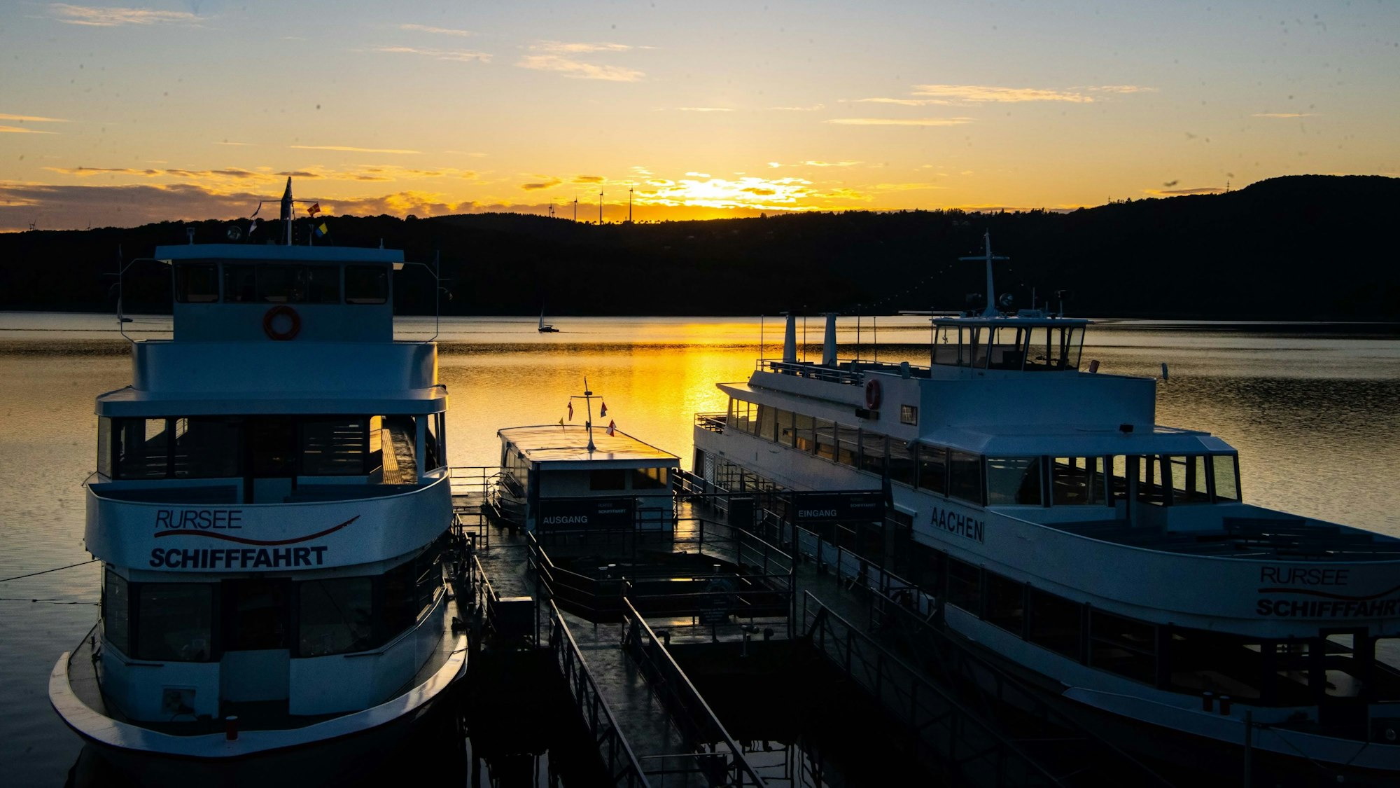 Zwei Schiffe auf dem Rursee, dahinter geht die Sonne unter. (Archivbild)