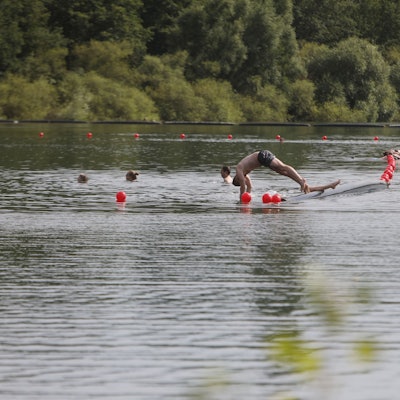 15.07.2024, Köln: Abkühlung am Fühlinger See. Ein paar Leute schwimmen im See.